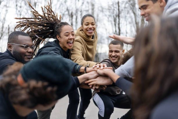 A group of people are putting their hands together in a circle.