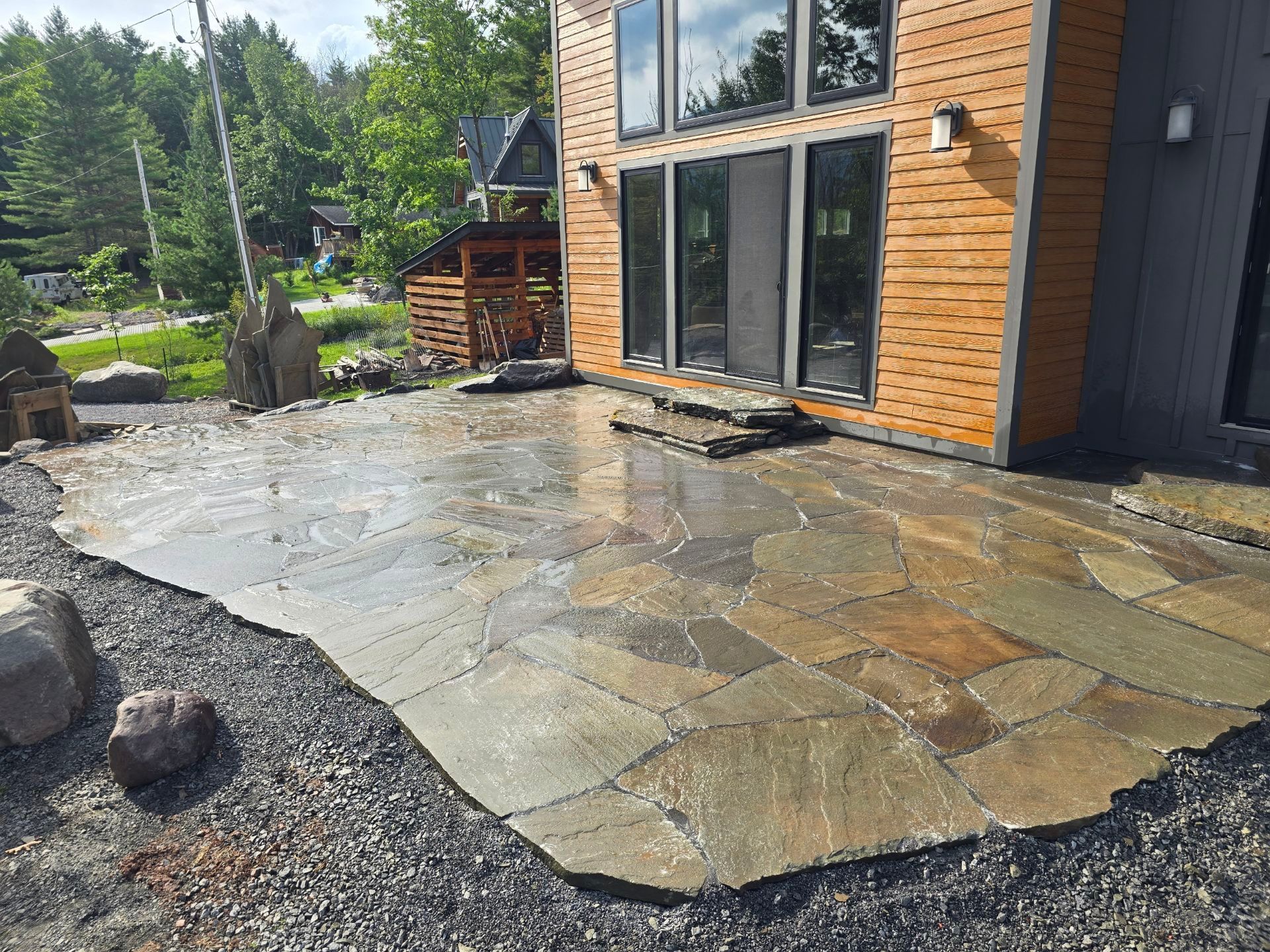 A dirt road surrounded by rocks and trees on a sunny day.