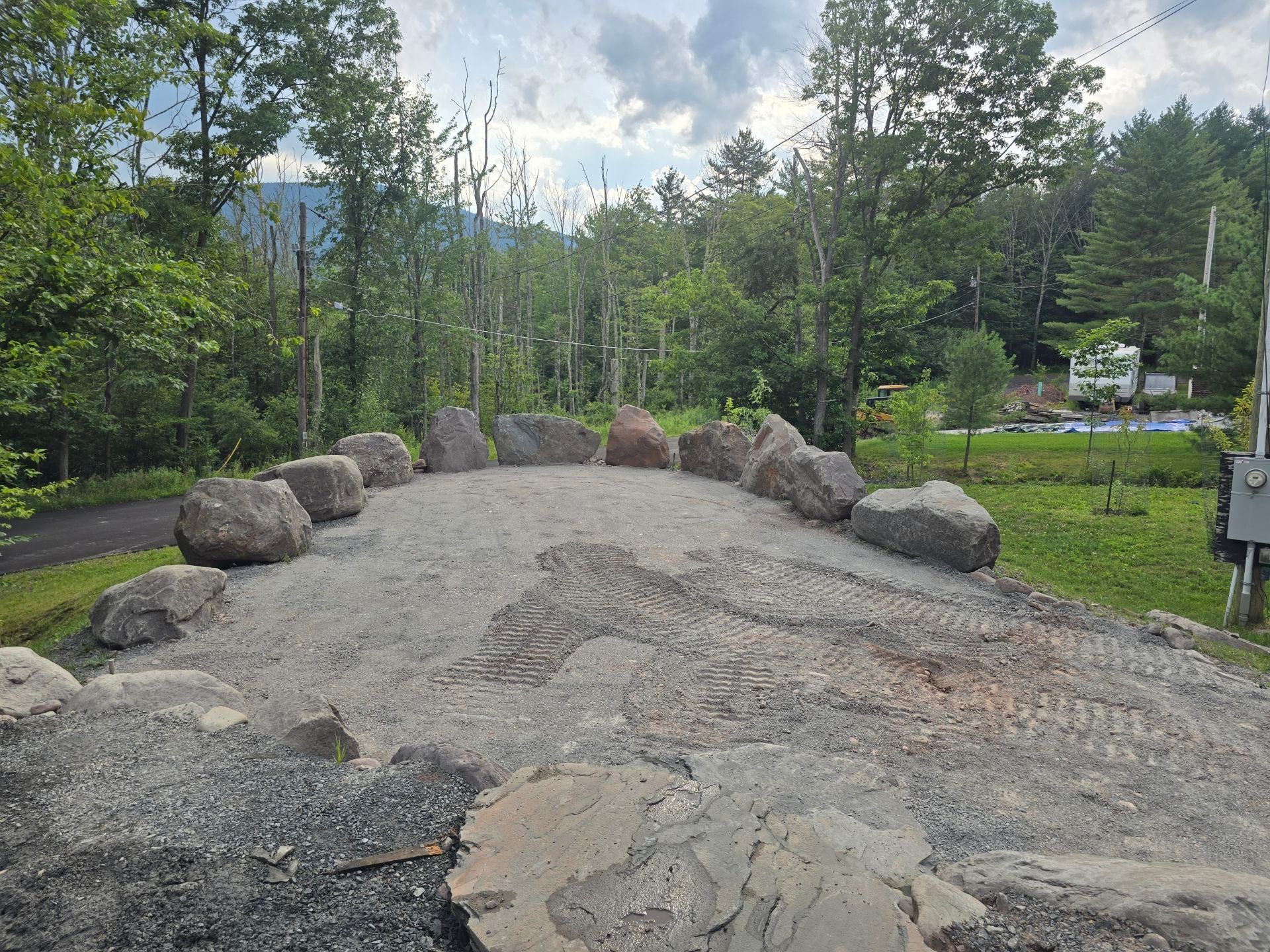A dirt road surrounded by rocks and trees on a sunny day.
