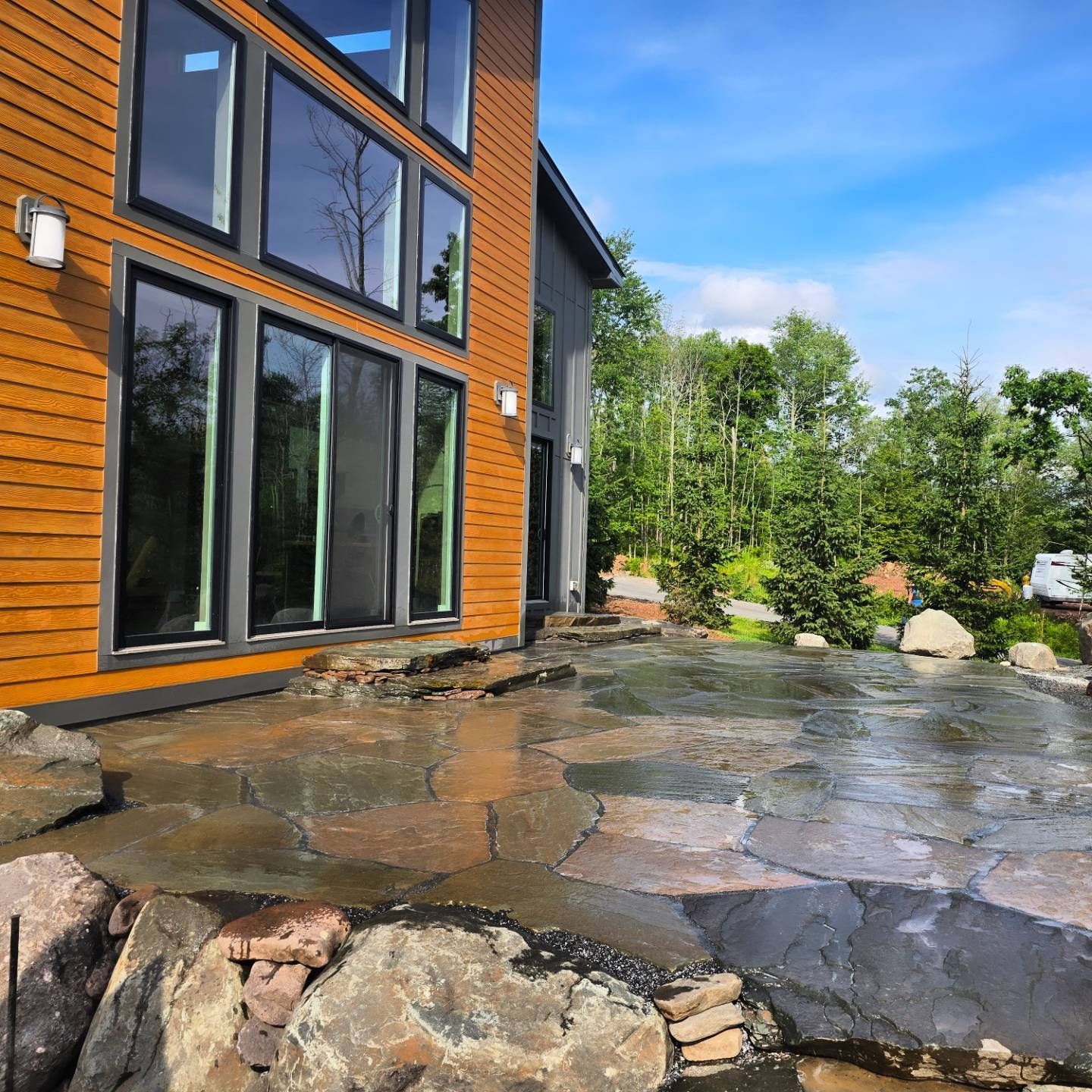 A house with a lot of windows and a patio in front of it