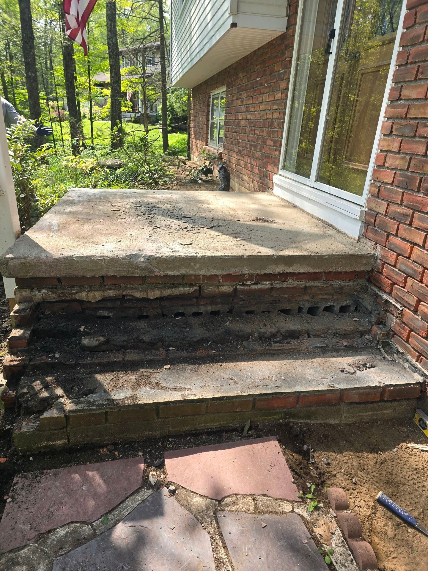 A brick house with a concrete porch and steps.