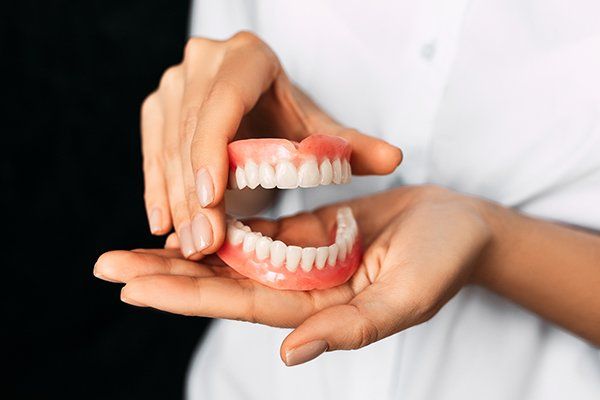 Dentist Holding Dentures — Central PA — Denture Center
