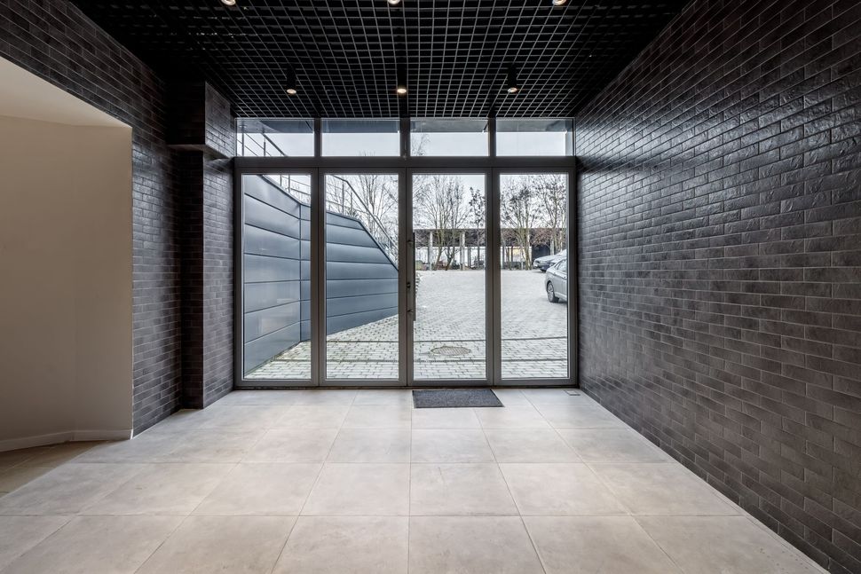 A large empty room with a lot of windows and a brick wall.