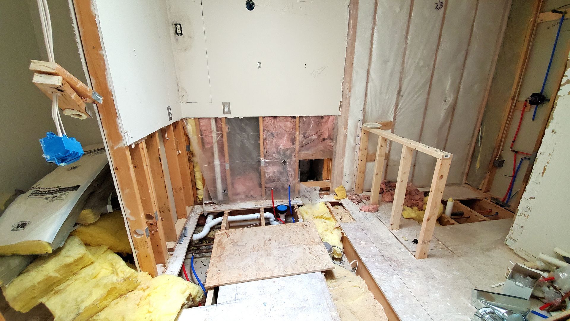 A bathroom under construction with a lot of insulation on the floor.