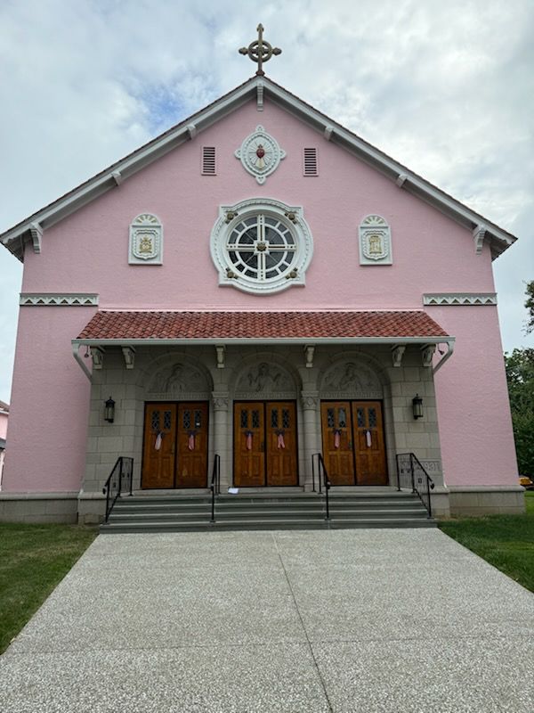 A pink church with a cross on top of it