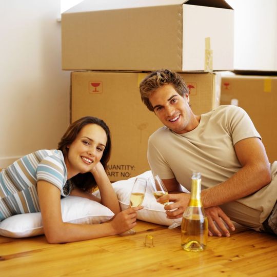 young couple in drinking wine in a new home