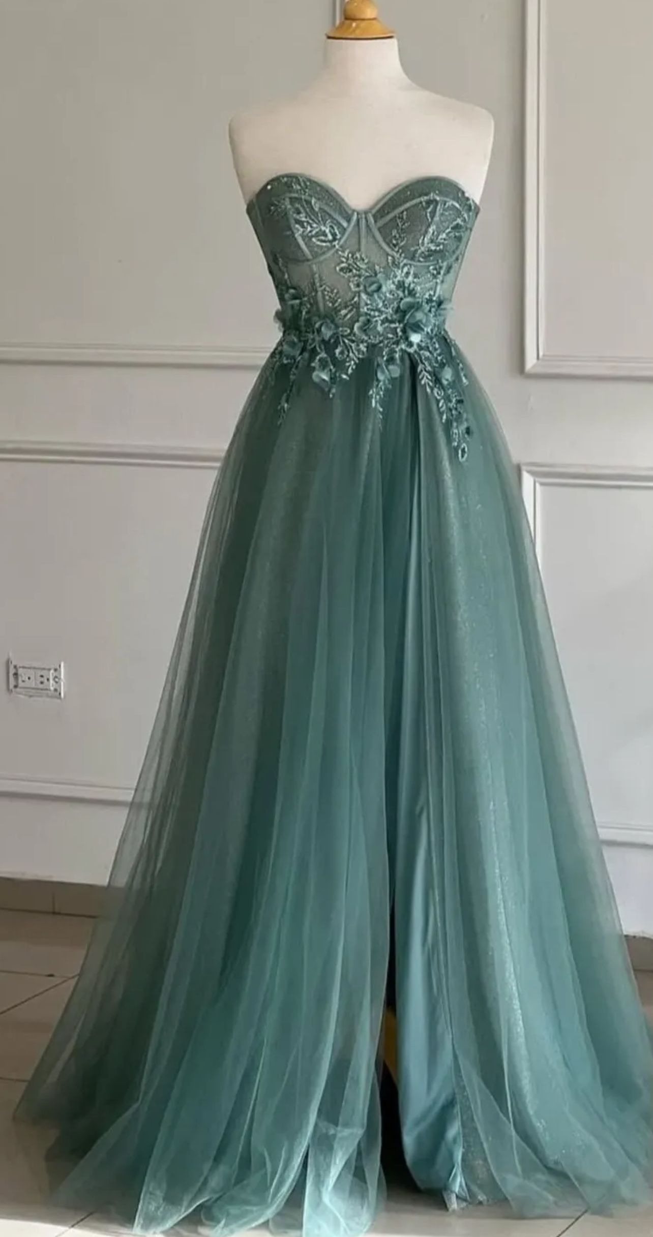 Sage green strapless formal gown with floral bodice embellishments, on a mannequin β Nur's Collection In Rockdale, NSW