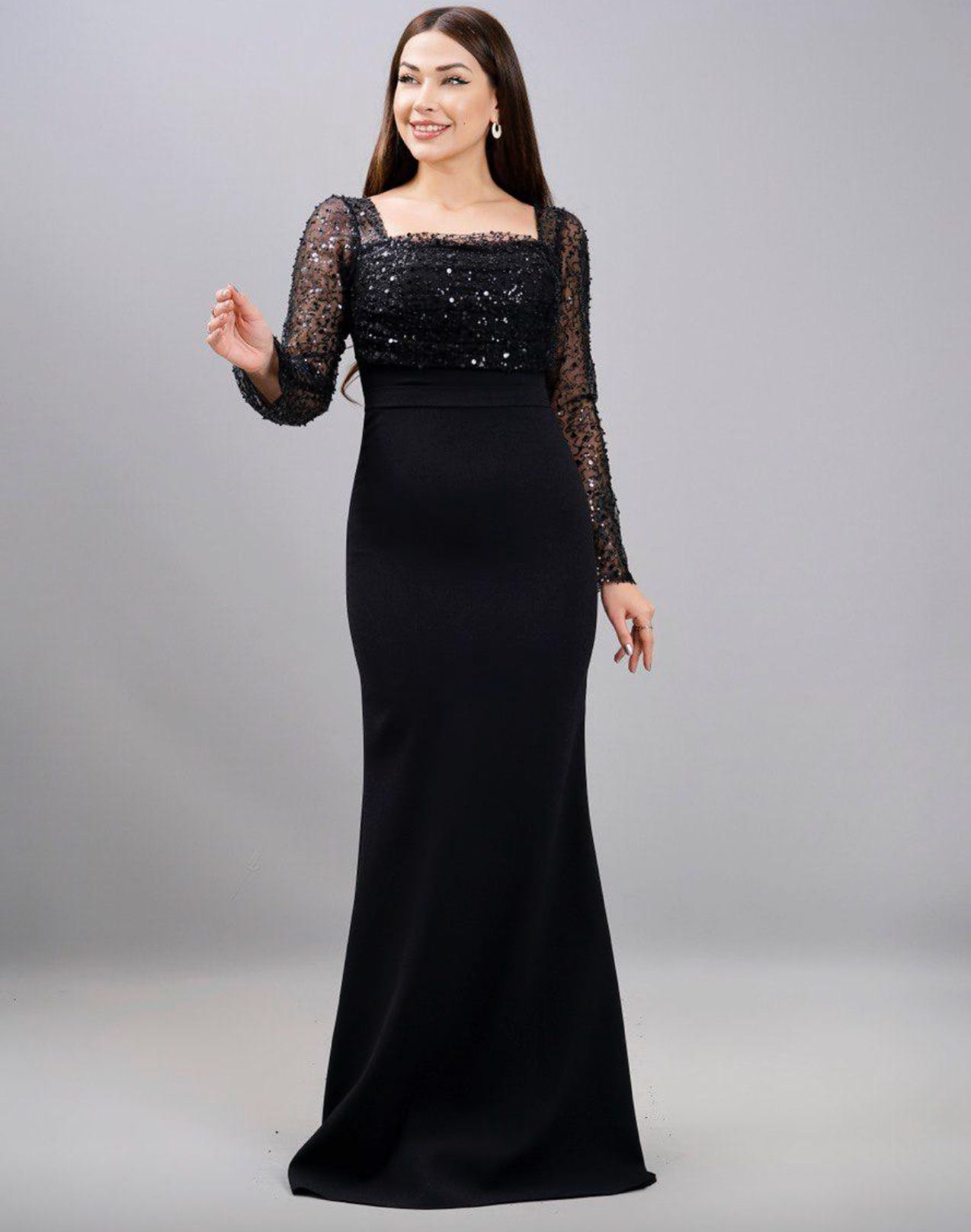 Woman in a black evening gown with a sequined bodice, square neckline, and long sleeves, smiling β Nur's Collection In Rockdale, NSW