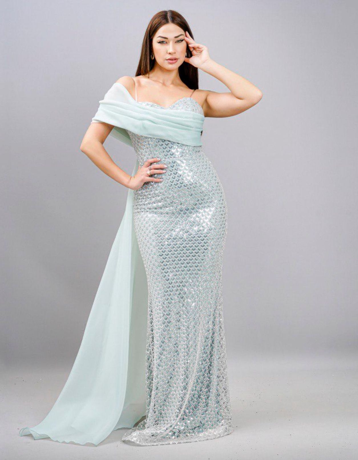 Woman in a sparkly, pale blue gown poses. She has dark hair, a hand on her head, and smiles — Nur's Collection In Rockdale, NSW
