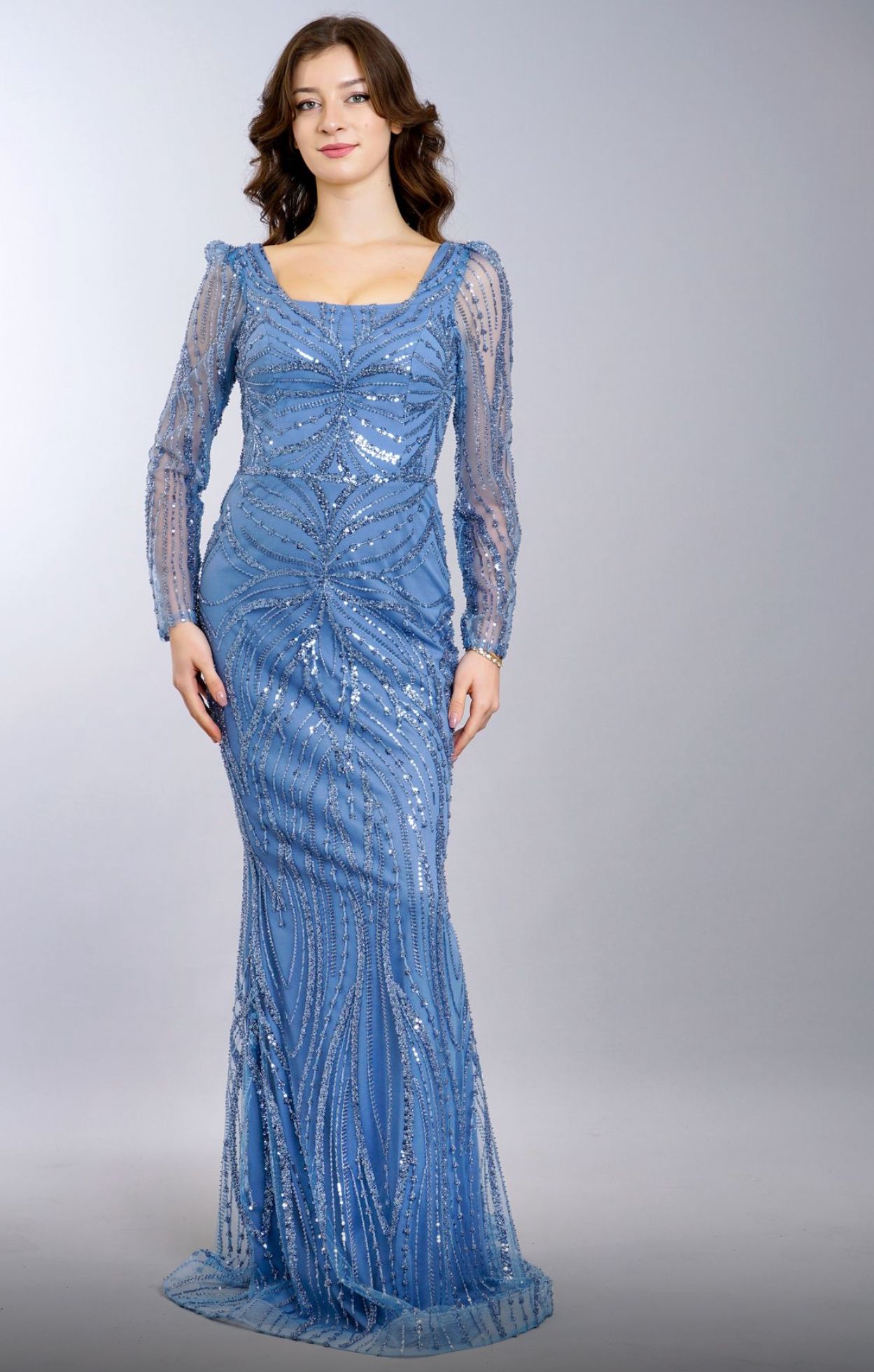 Woman in a long, blue sequined gown with long sleevesβ Nur's Collection In Rockdale, NSW