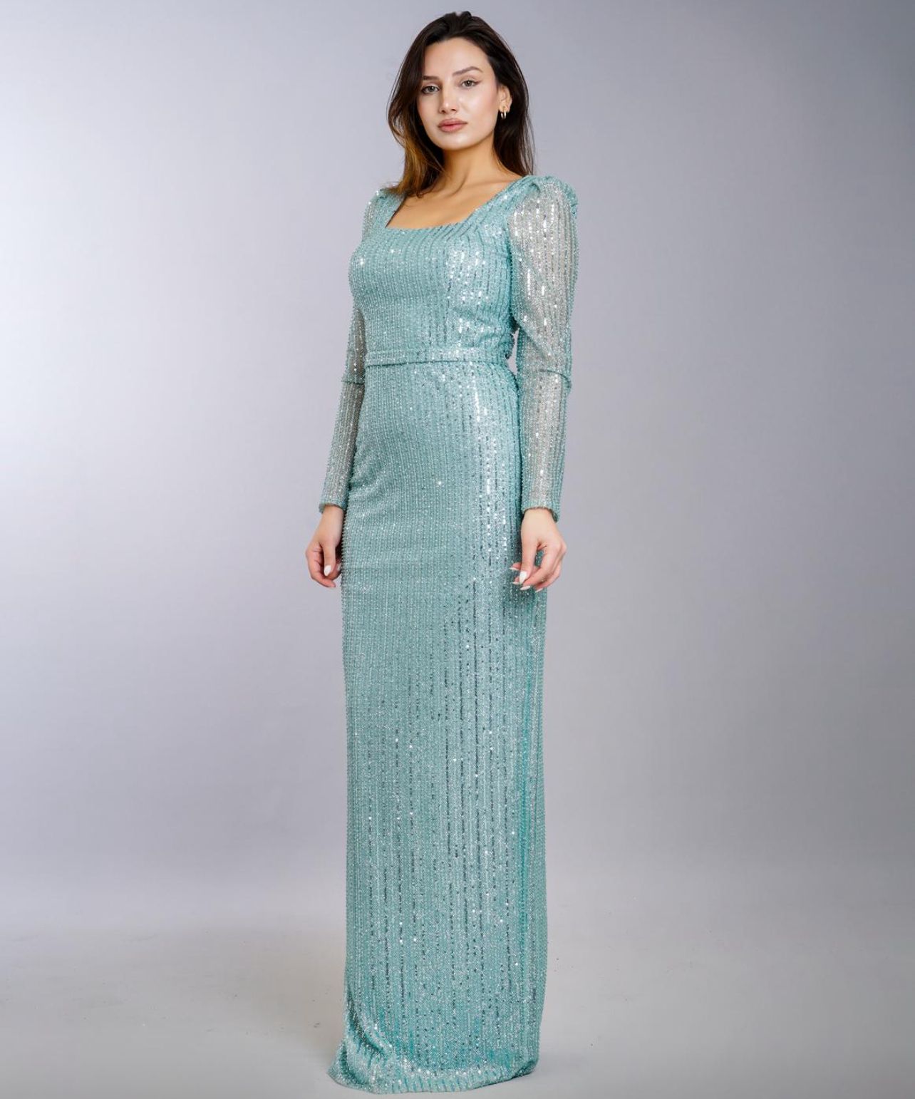 Woman in a long, sequined light blue gown with long sleeves, posed against a gray backdrop  — Nur's Collection In Rockdale, NSW