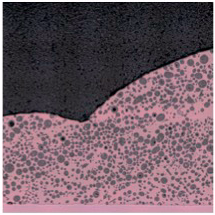 Microscopic view of solder joint, showing metallic spheres within a pink matrix, against a dark, uneven surface.