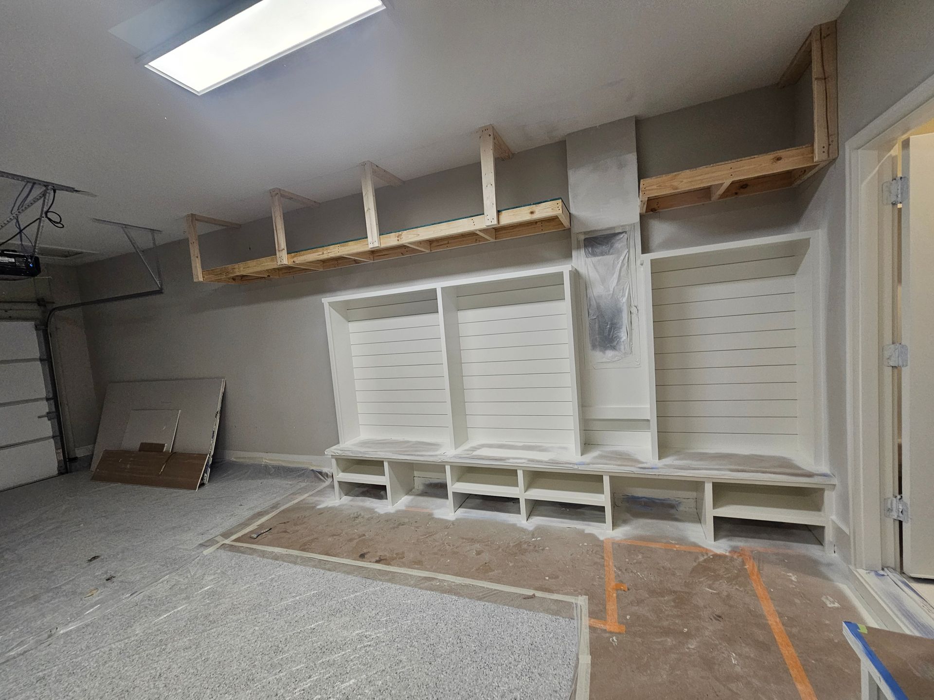 A garage with a lot of shelves and benches in it.