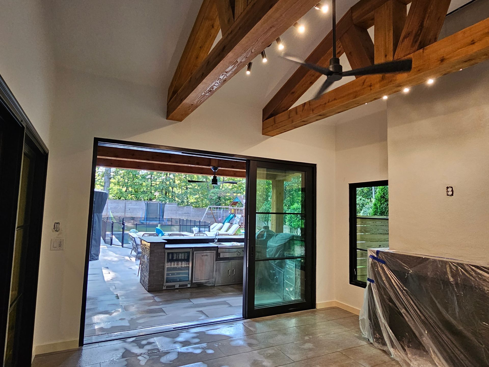 A room with a ceiling fan and sliding glass doors leading to a patio.
