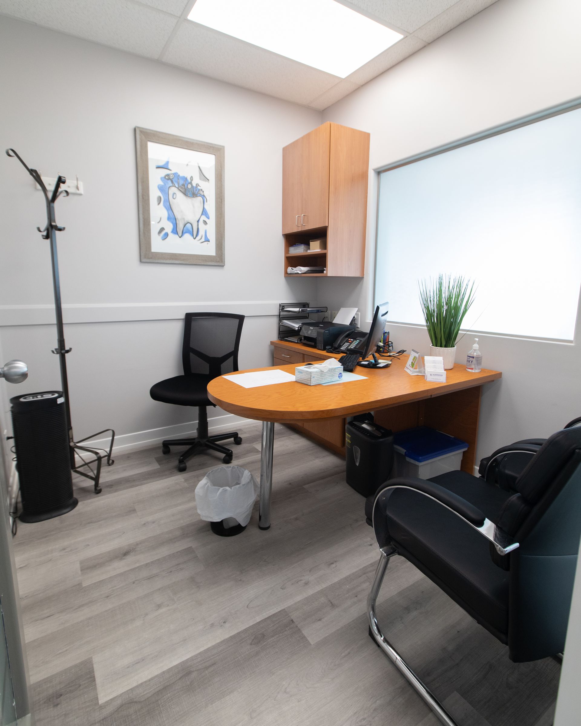 Office with desk, chairs, and window; neutral colors.