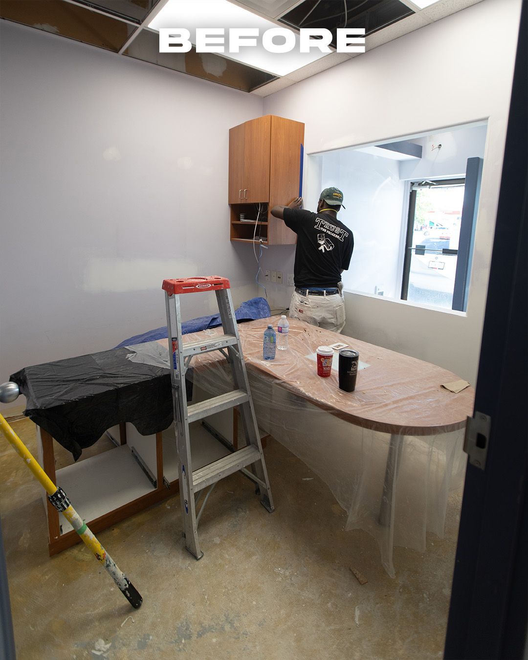 Office Room under renovation with a worker painting a wall near a window
