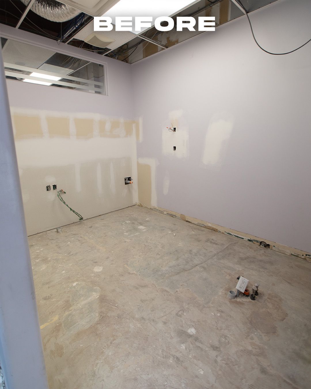 Empty room with unfinished walls, electrical outlets, and exposed concrete floor. Text 