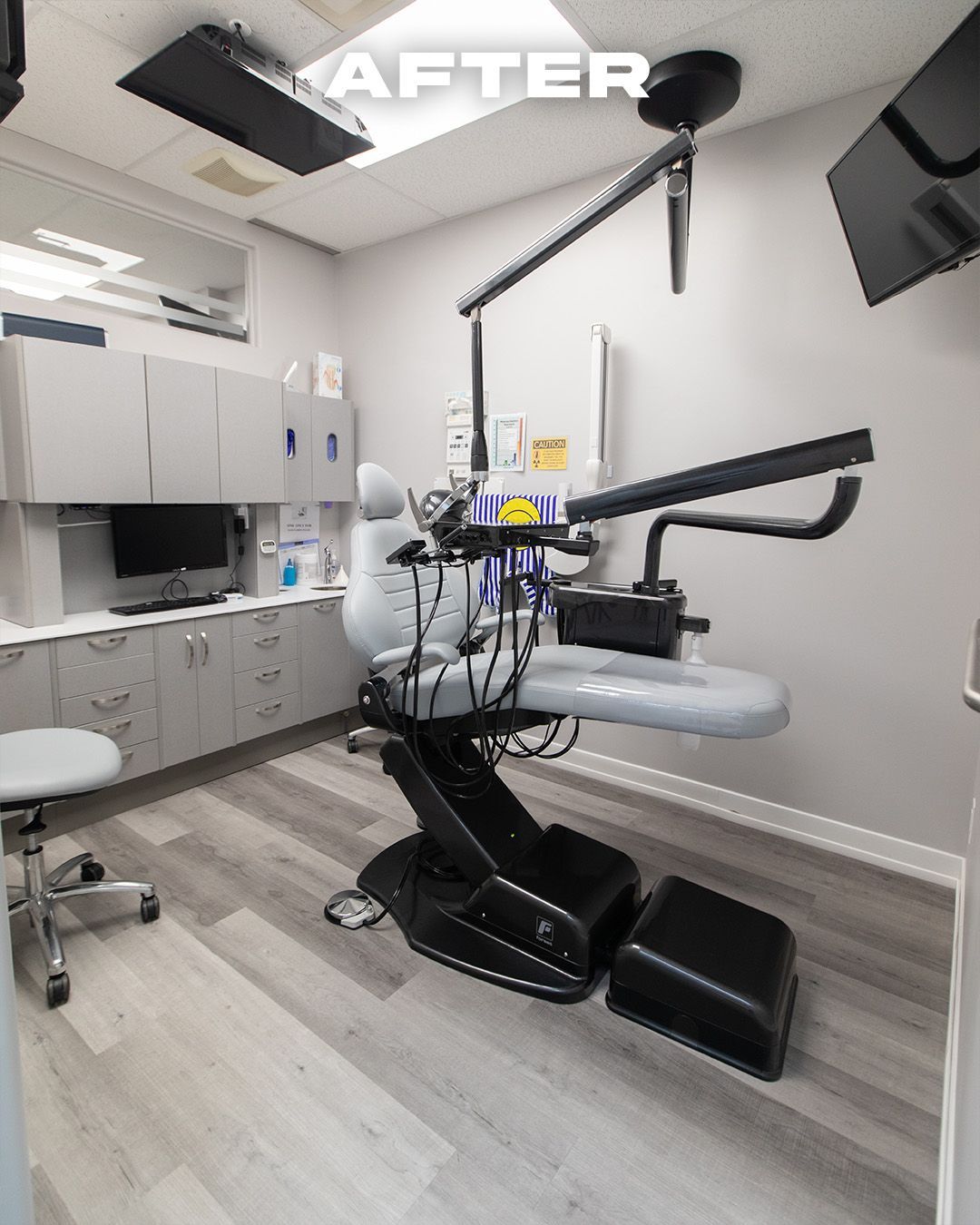 Dental office interior with gray cabinetry, dental chair, and equipment. 