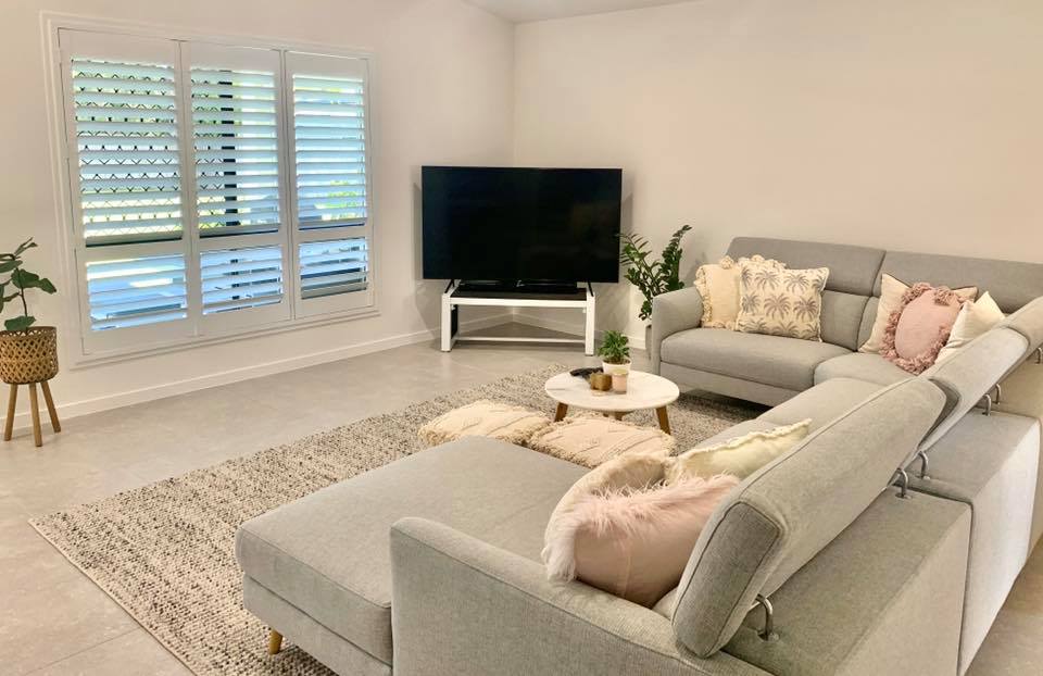 Living Room Window With Wooden Shutters — Window Coverings in Currajong, QLD