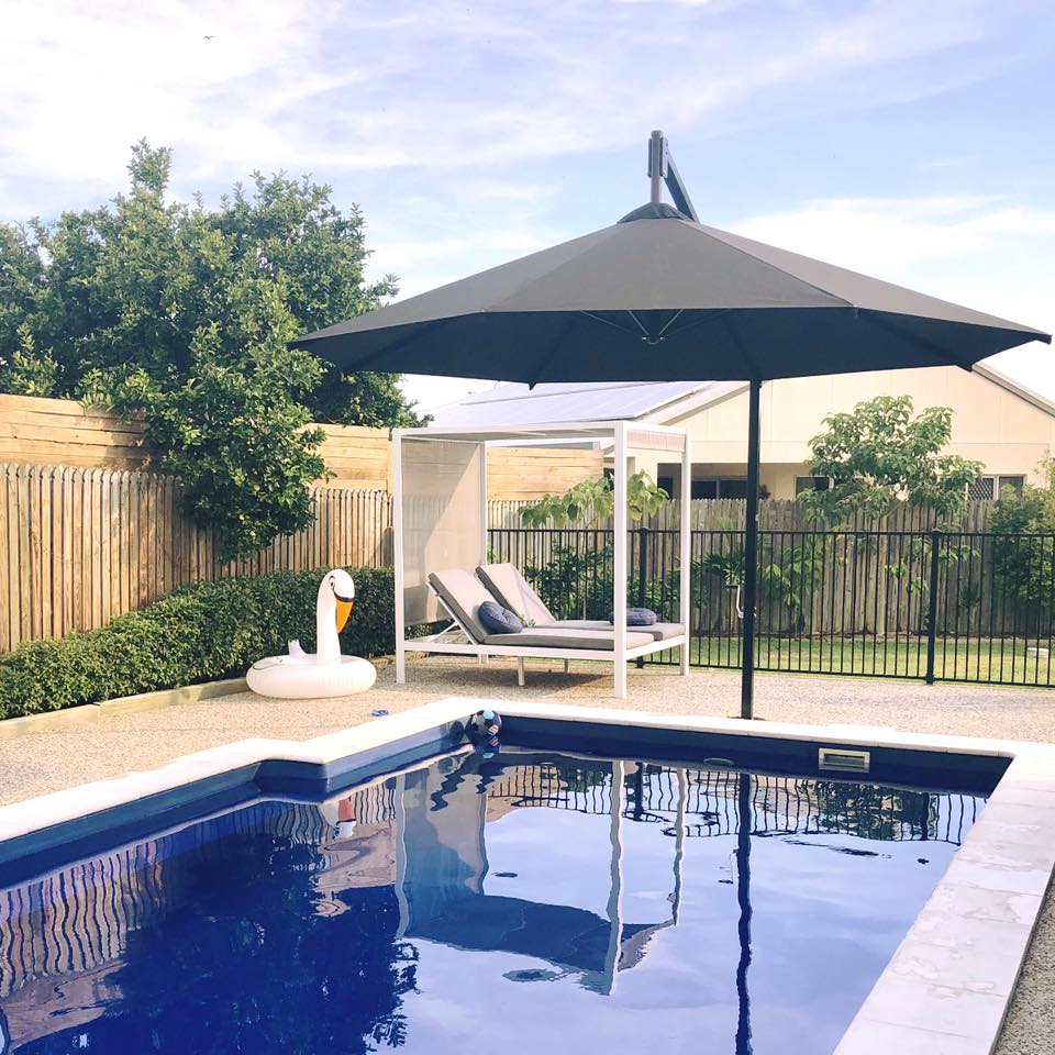 Pool Area With Large Umbrella For Shade — Window Coverings in Currajong, QLD