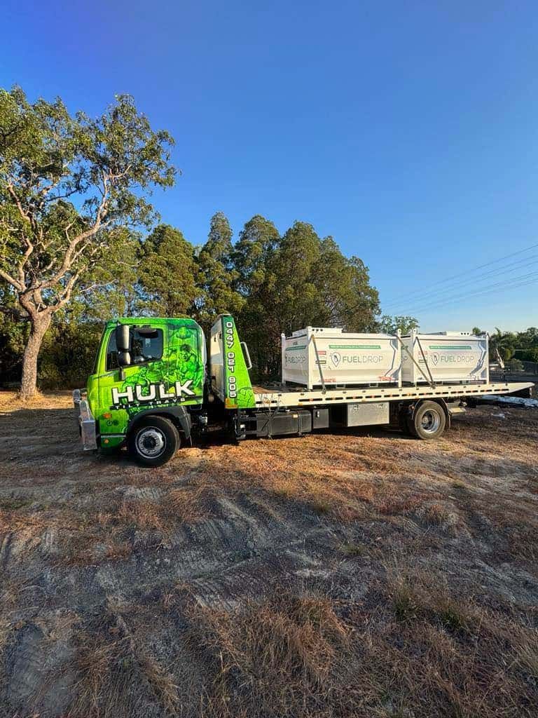 A Green Tow Truck Is Parked in A Field Next to A Tree — Hulk Tilt Trays In Humpty Doo, NT
