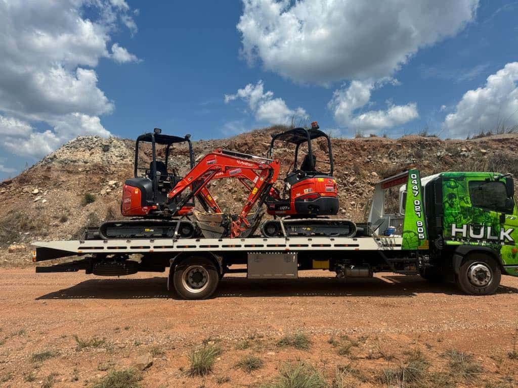 A Crane Is Carrying a Container on A Trailer Down a Street — Hulk Tilt Trays In Humpty Doo, NT