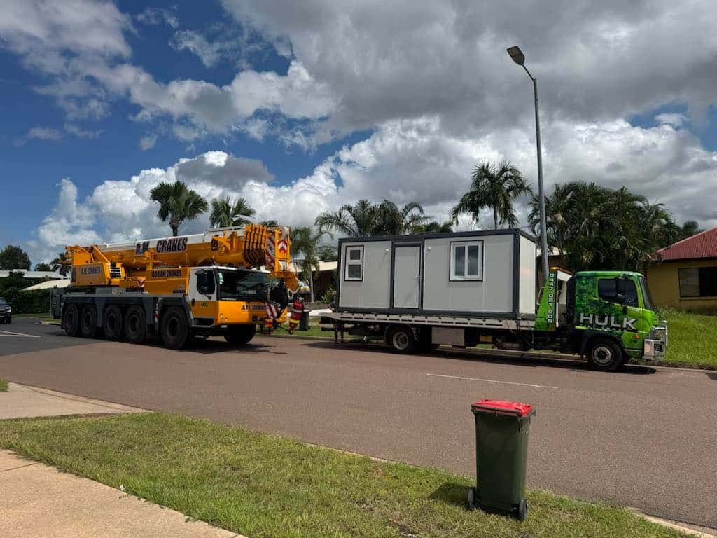 A Crane Is Carrying a Container on A Trailer Down a Street — Hulk Tilt Trays In Humpty Doo, NT