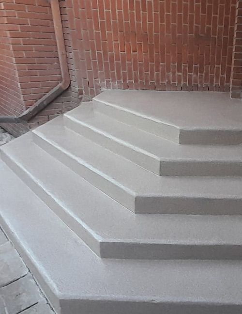 Marches en béton menant à un mur de briques.