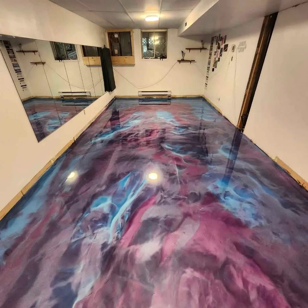 Chambre avec sol en époxy évoquant une nébuleuse, reflétant un grand miroir mural. Couleurs : bleu, violet et blanc.