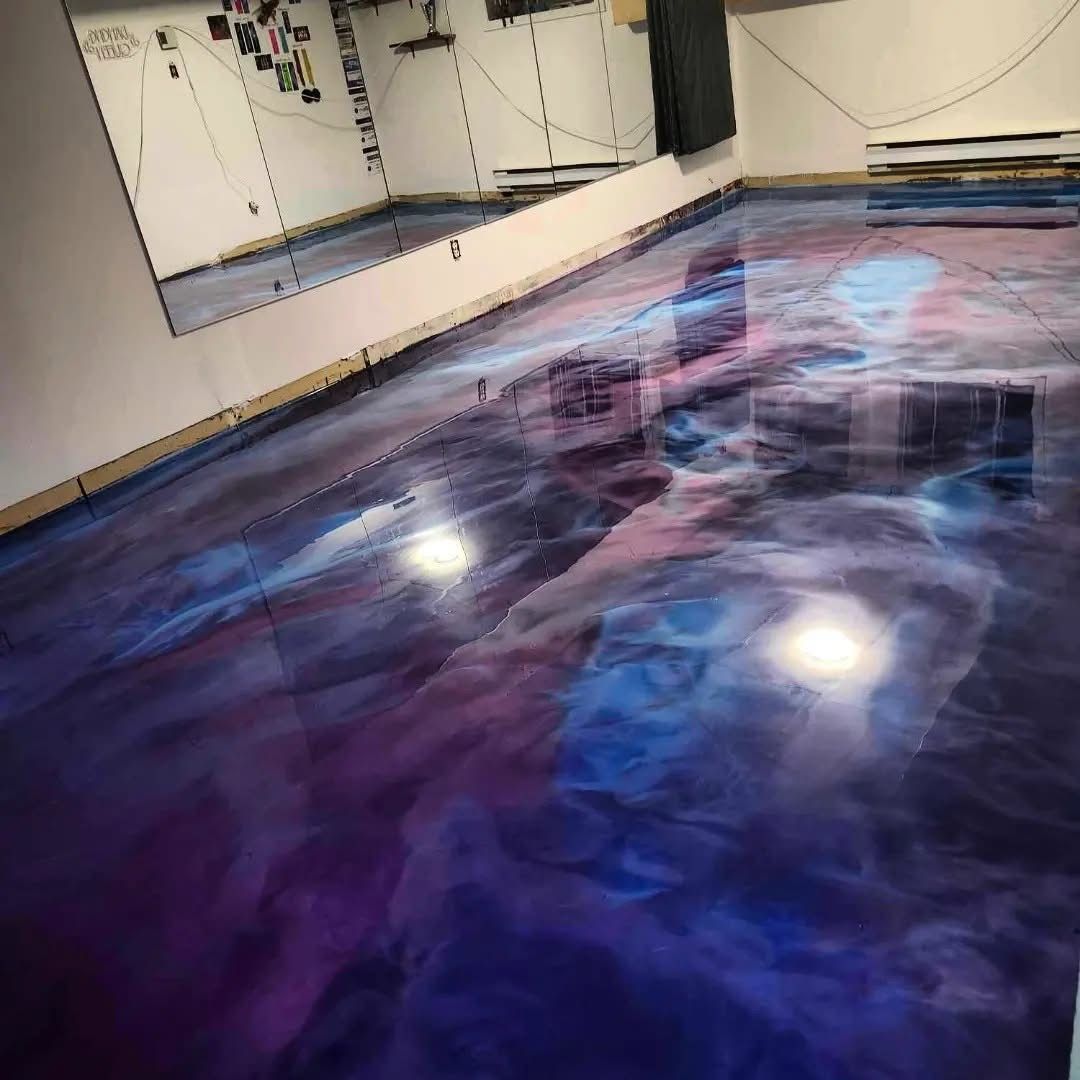 Sol époxy aux couleurs tourbillonnantes violettes, bleues et blanches, ressemblant à une galaxie, dans une pièce avec un miroir.