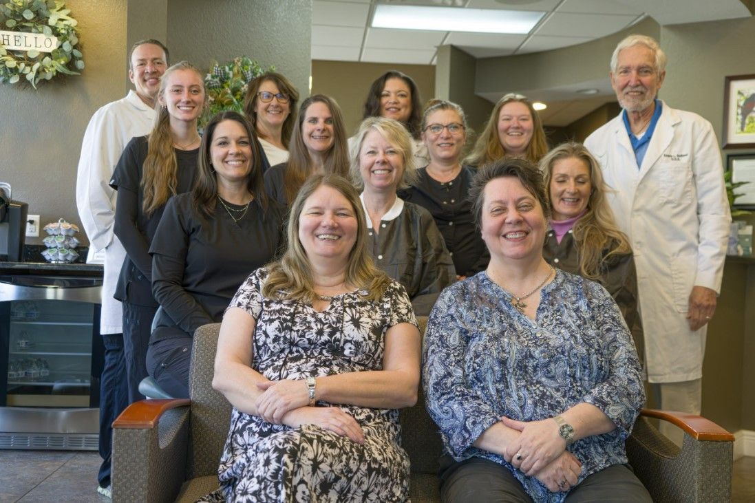A group of people are posing for a picture in a dental office.