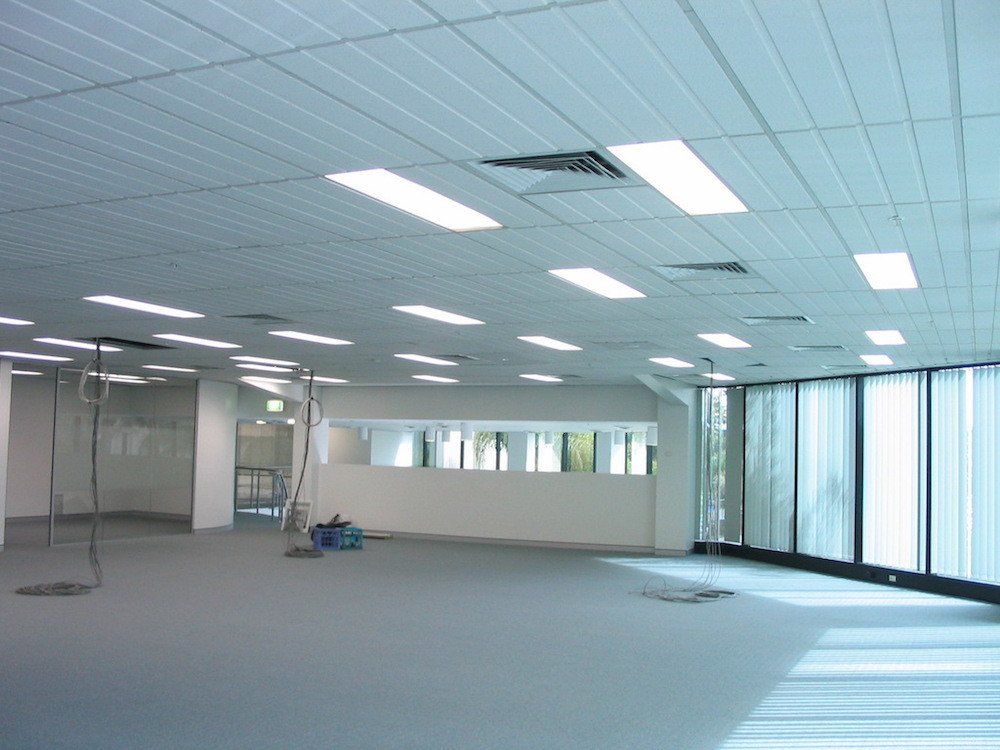 a large empty room with lots of windows and lights on the ceiling