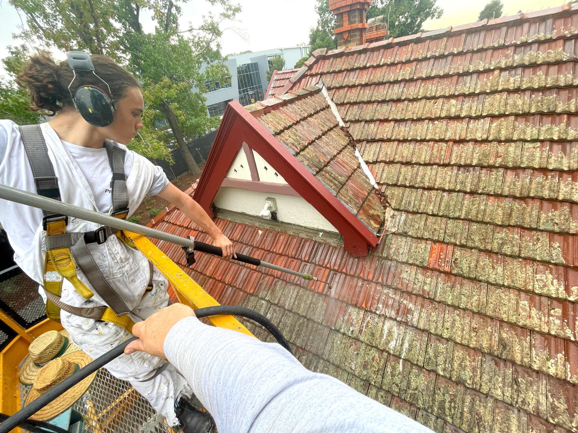 a man is spraying a roof with a hose .