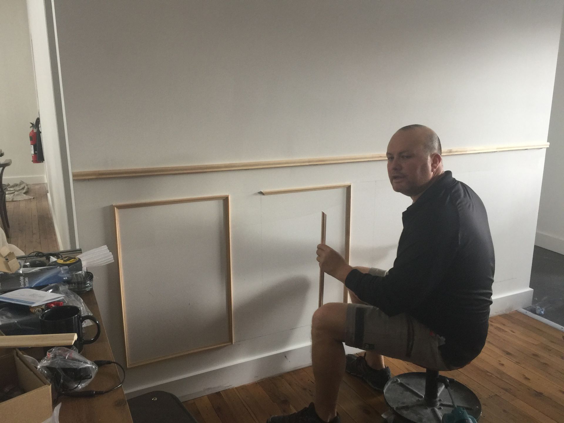 a man is sitting on a stool in front of a wall .