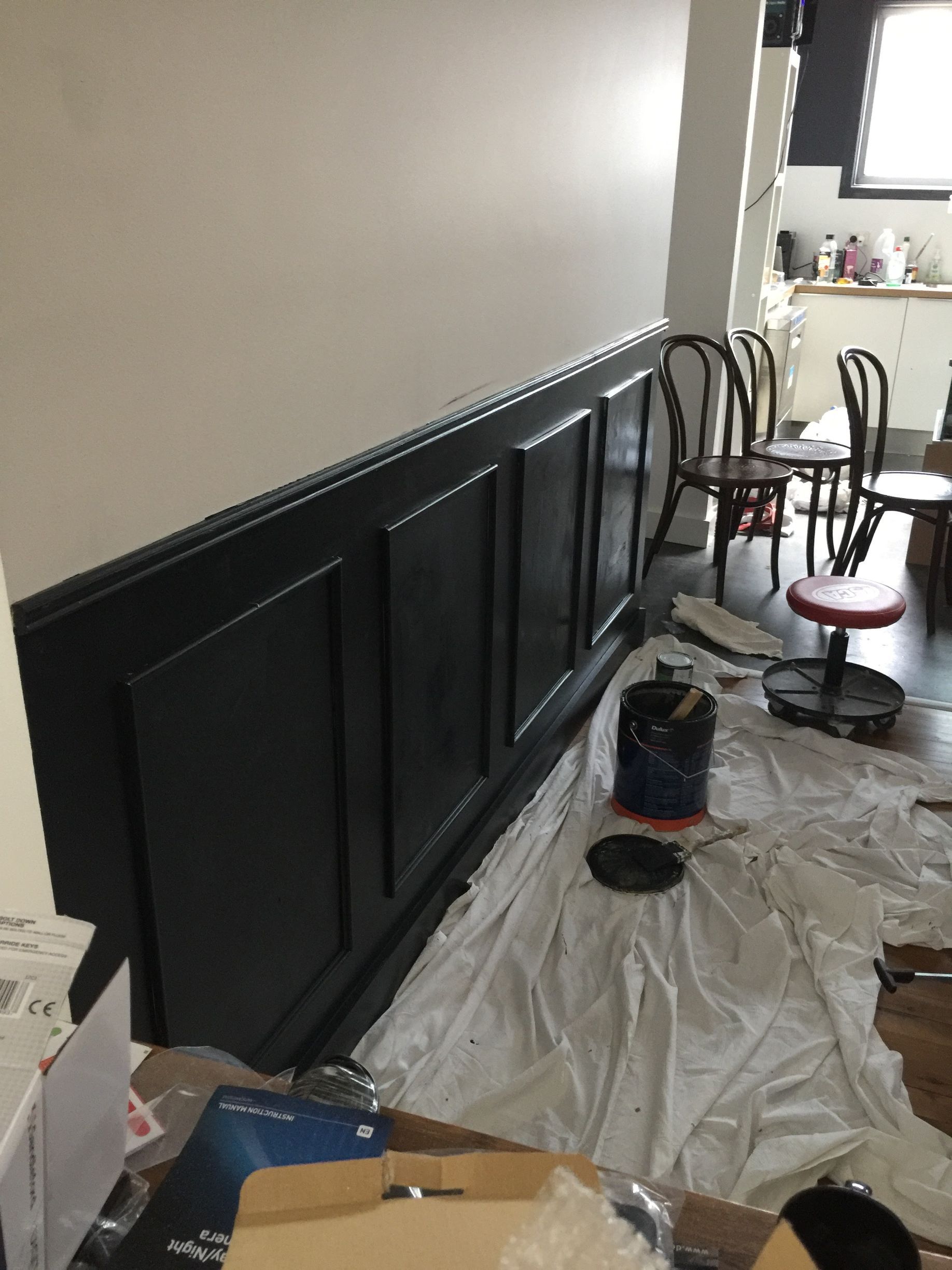 a room is being painted with a bucket of paint on the floor .