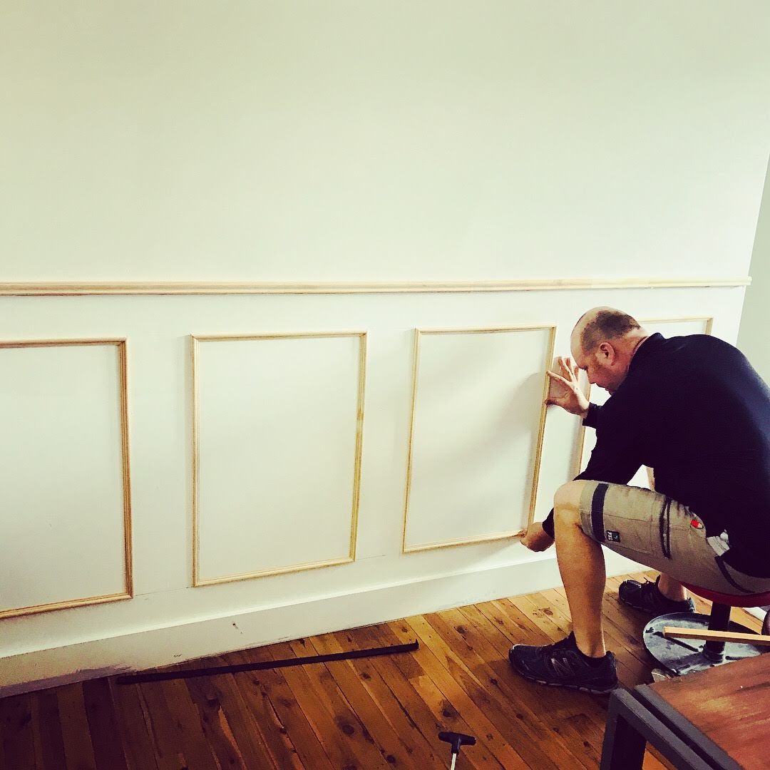 a man is kneeling down and working on a wall