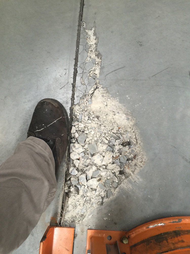 a person standing on a concrete floor next to a pile of rocks