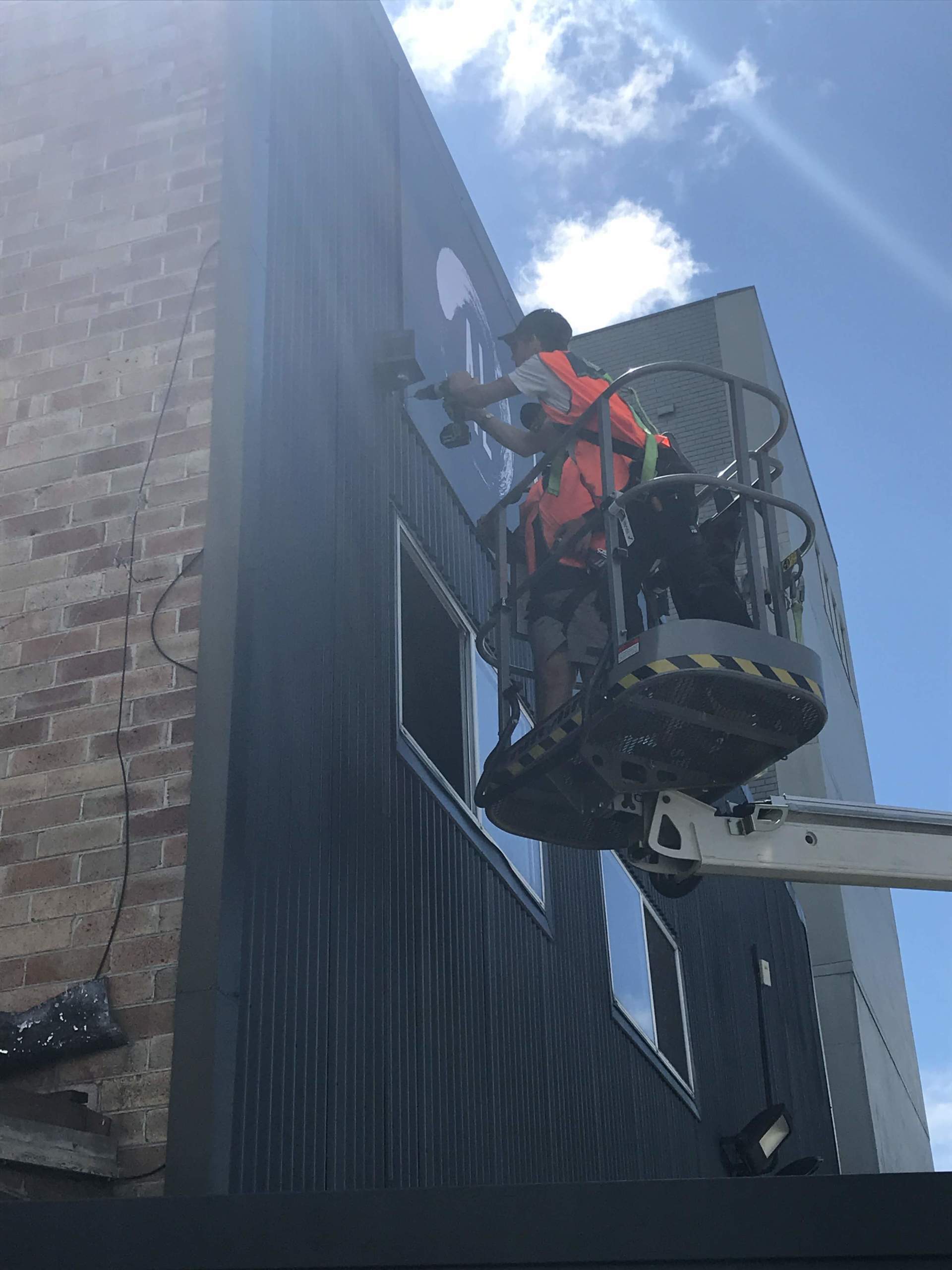 a man is working on the side of a building on a lift .