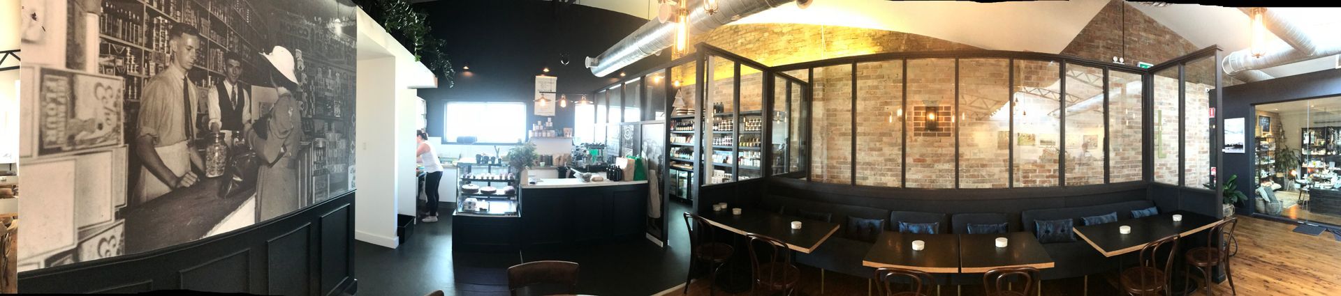 a panoramic view of a restaurant with tables and chairs .