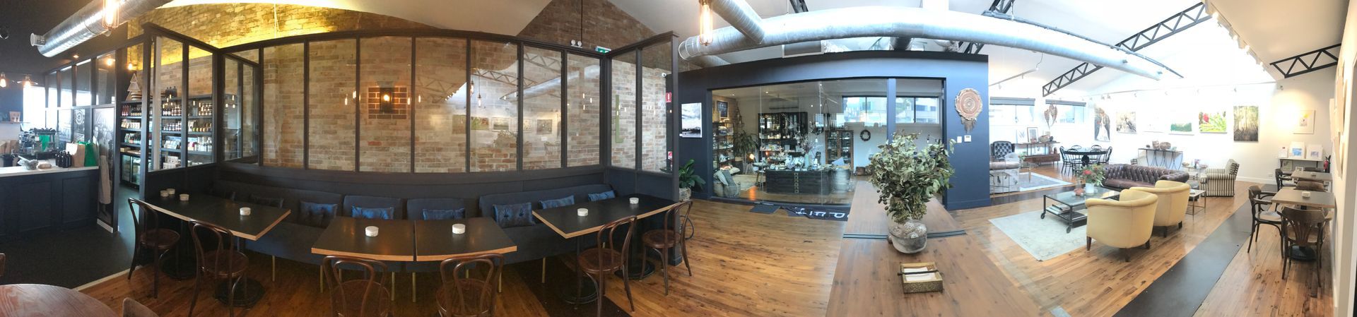 a panoramic view of a restaurant with tables and chairs .