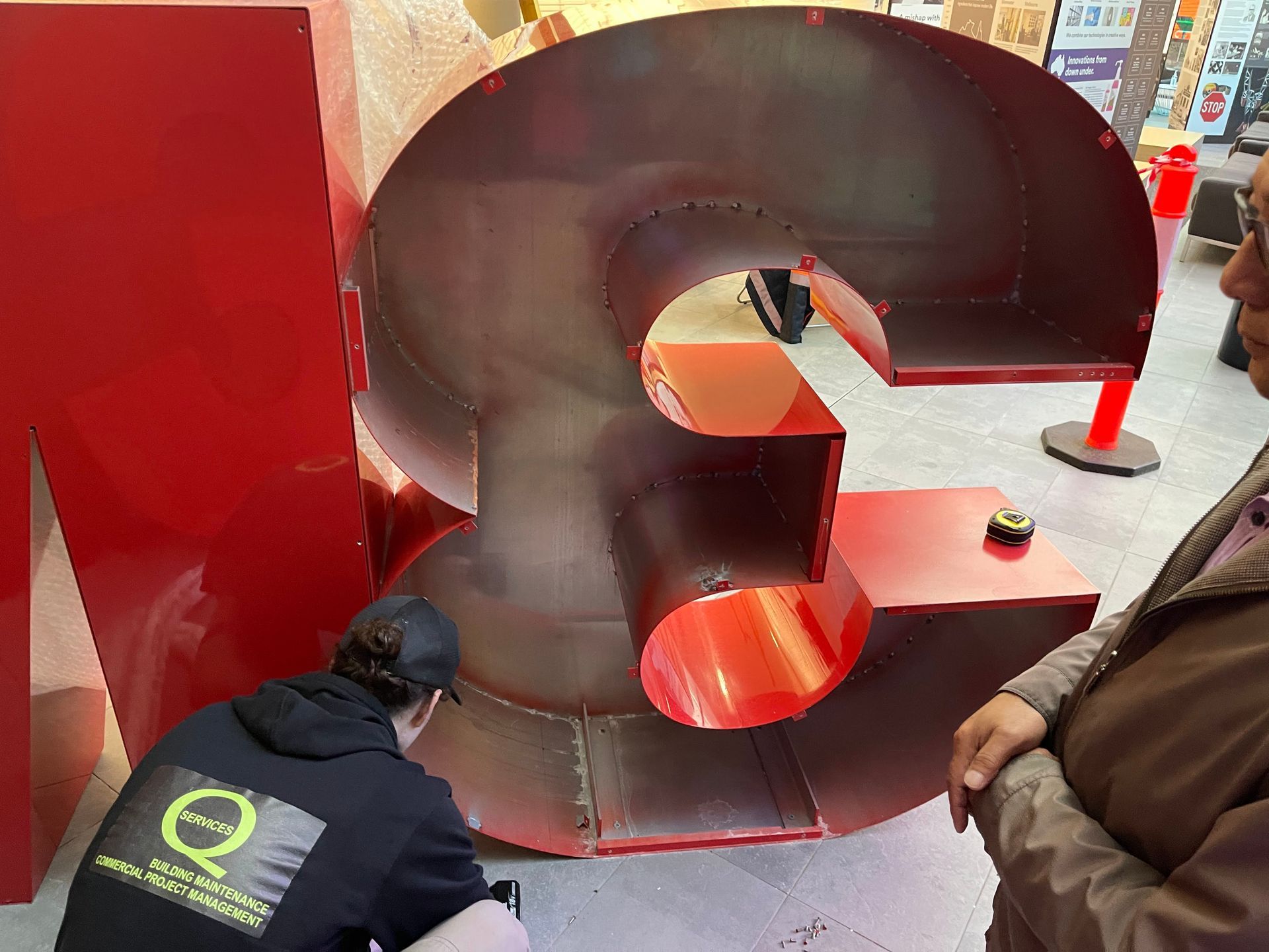 a man is kneeling down in front of a large red number 3