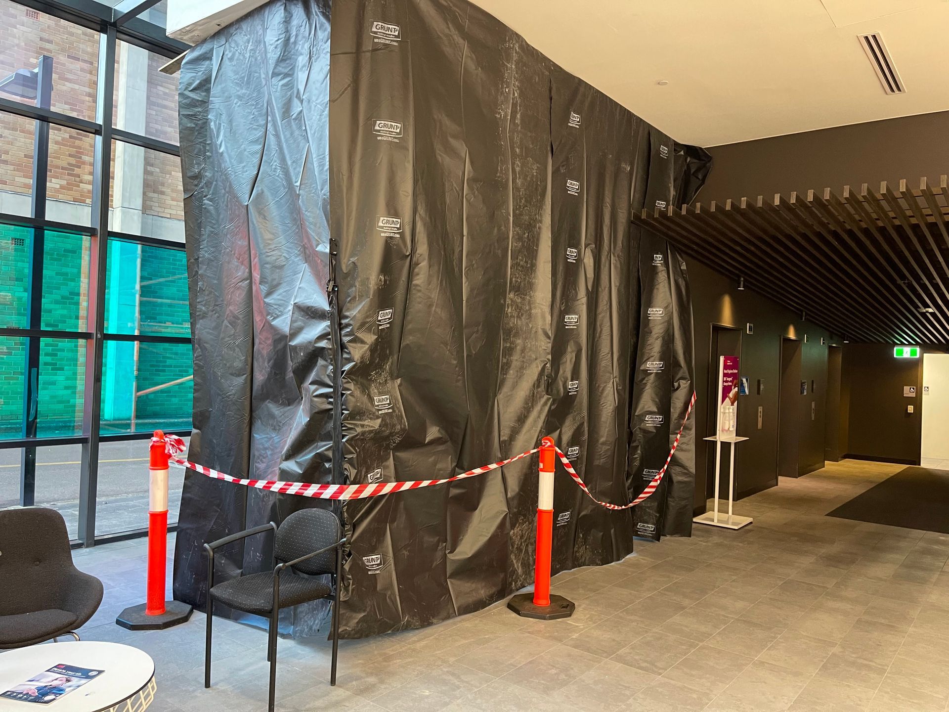a room with a black curtain covering the wall and chairs .
