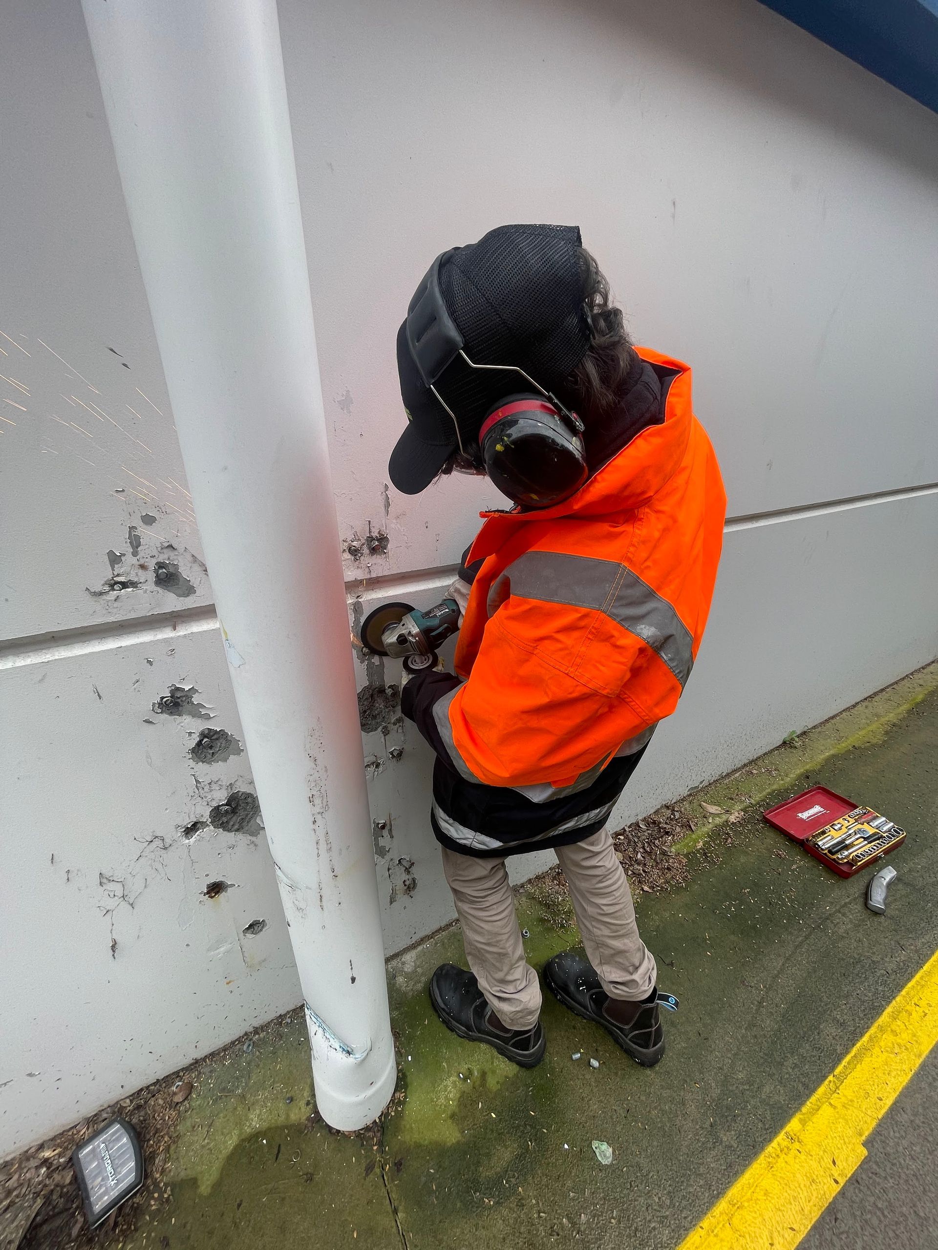 a man wearing headphones is working on a wall .