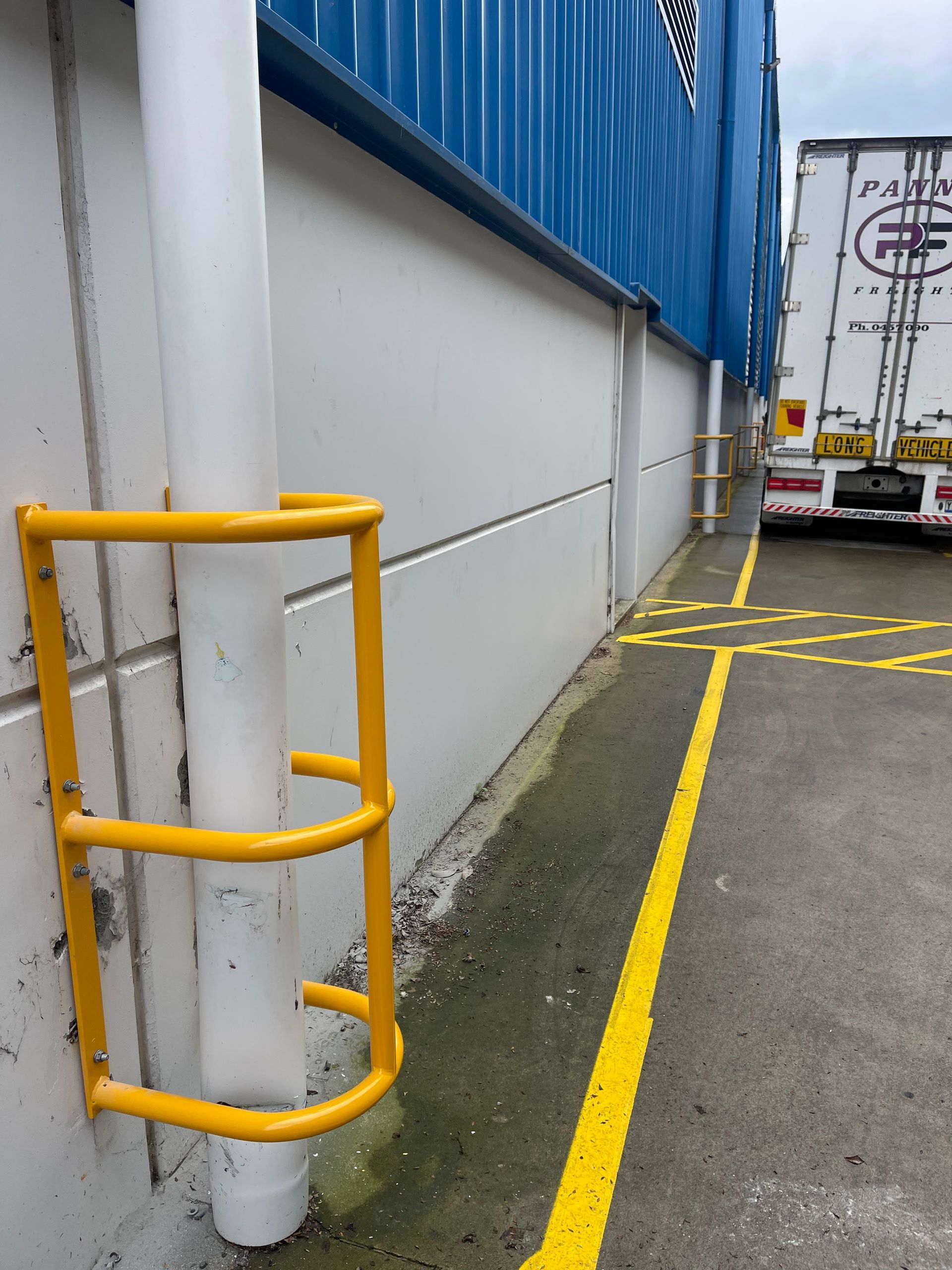 a truck is parked on the side of a building next to a yellow line .
