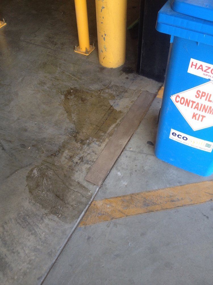 a blue spill containing kit sits on a concrete floor