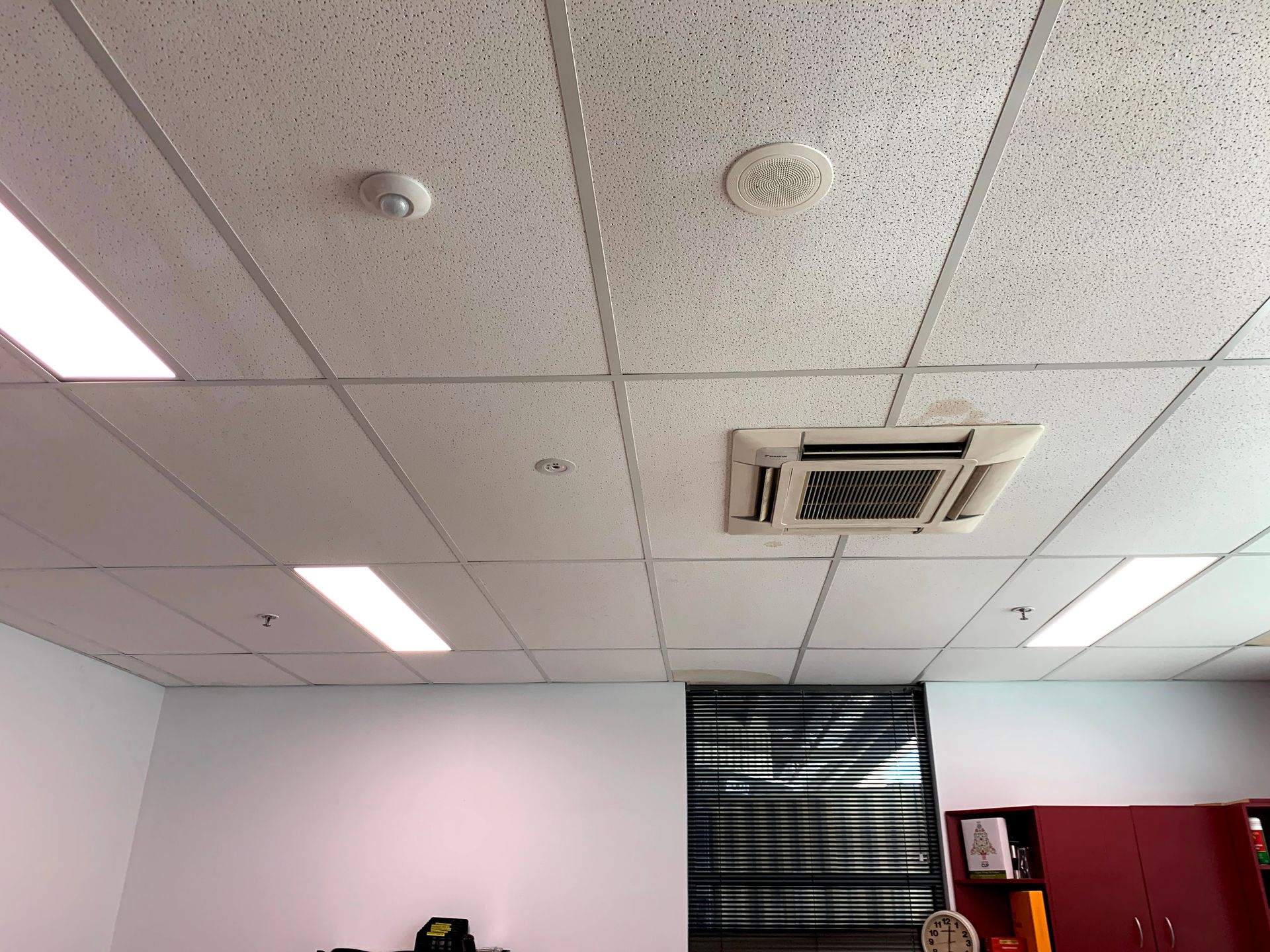 a room with a ceiling fan and a smoke detector on it .