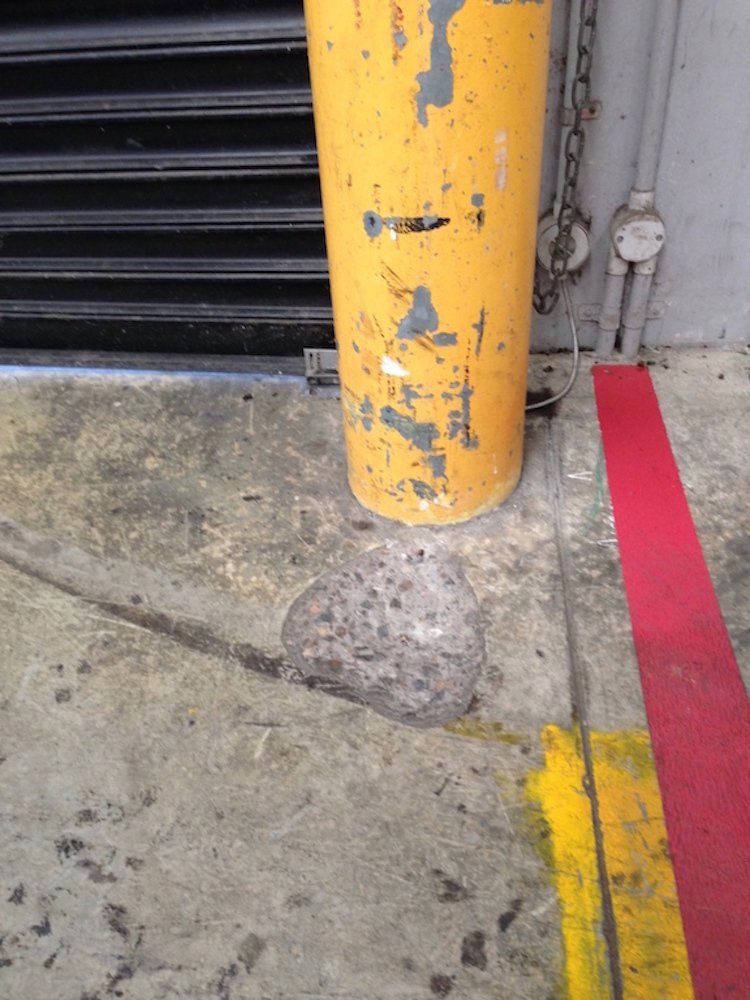 a yellow pole in a parking lot next to a red line