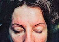 Person receiving eyebrow microblading. Black gloved hands holding tools near eye. Brown eyebrow partially shaded.