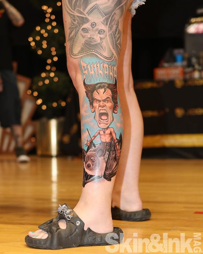 A person's arm undergoing laser tattoo removal. A device is held over the tattoo by someone wearing black gloves.