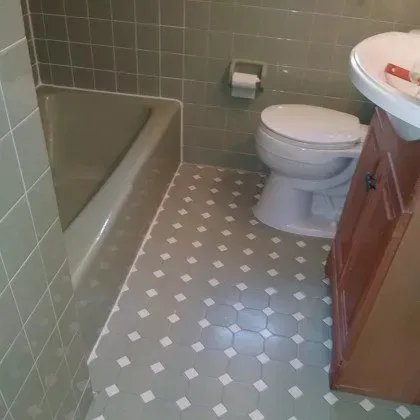 A bathroom with a toilet , sink and bathtub.